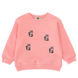 A pink crewneck sweatshirt featuring four embroidered black and white cat motifs on the front, displayed against a solid white background.