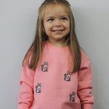 Child wearing pink kids’ tracksuit bottoms with cat design