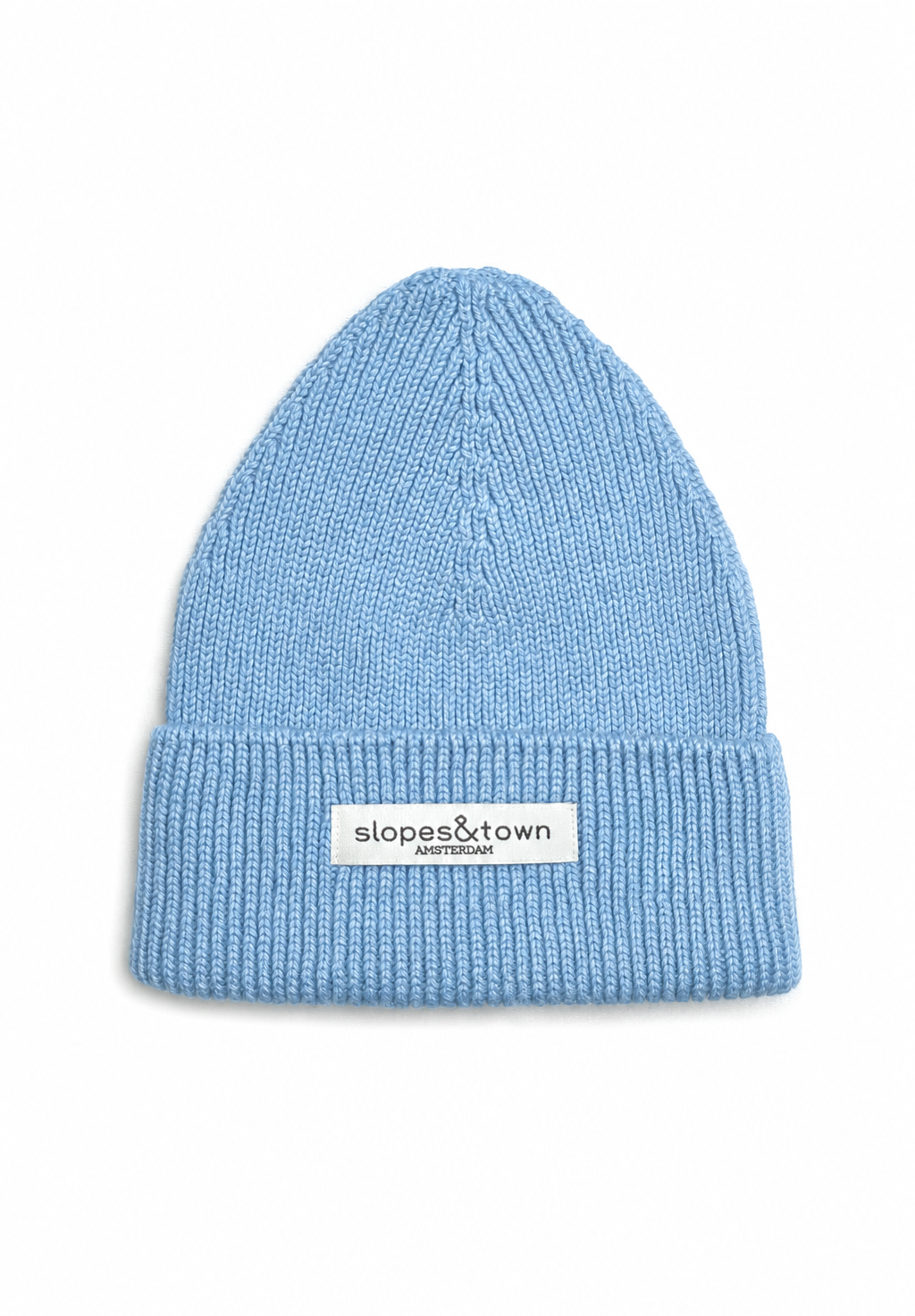 A light blue ribbed knit beanie hat with a white rectangular brand patch on the front cuff that reads 'slopes&town amsterdam'. The beanie is photographed flat against a clean white background.