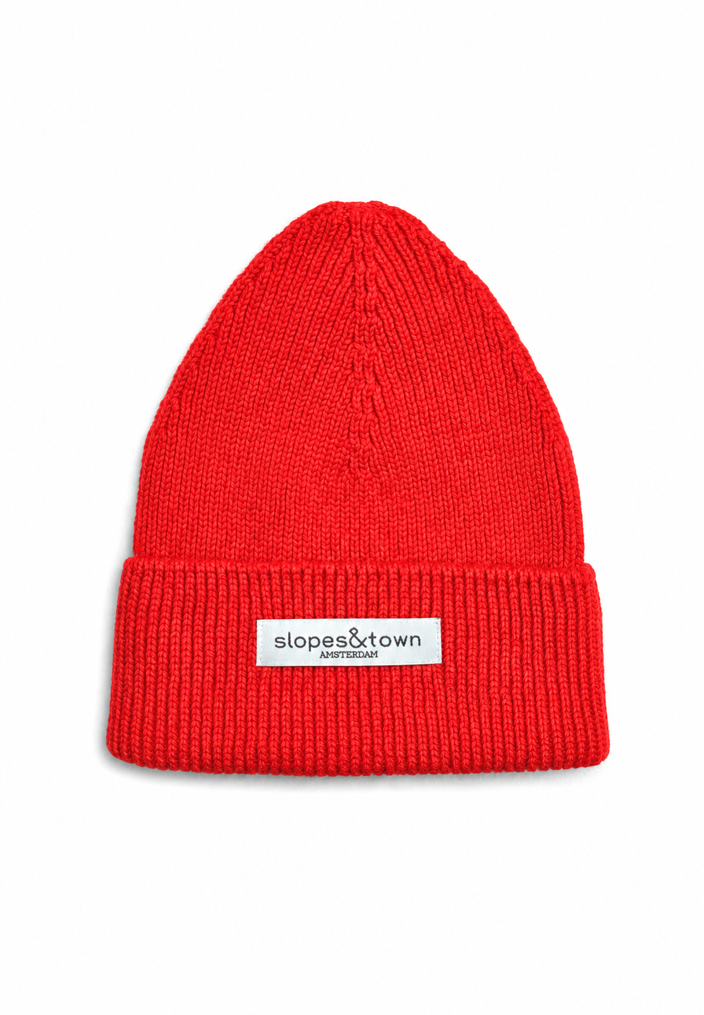 A bright red ribbed knit beanie hat with a folded cuff, featuring a small white rectangular label that reads 'slopes&town Amsterdam'. The beanie is photographed against a clean white background.