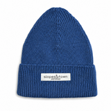 A blue ribbed knit beanie hat with a folded cuff and a white rectangular label reading 'slopes&town AMSTERDAM' on the front
