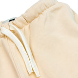 Close-up of white terrier embroidery on beige kids' sweatpants