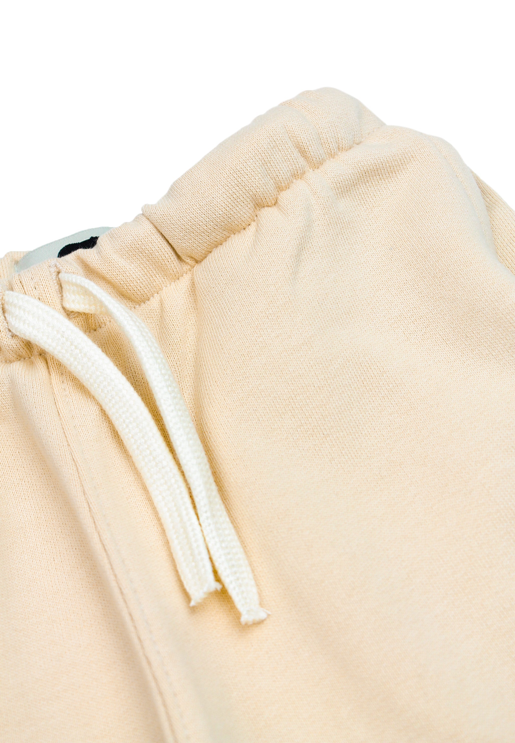 Close-up of white terrier embroidery on beige kids' sweatpants
