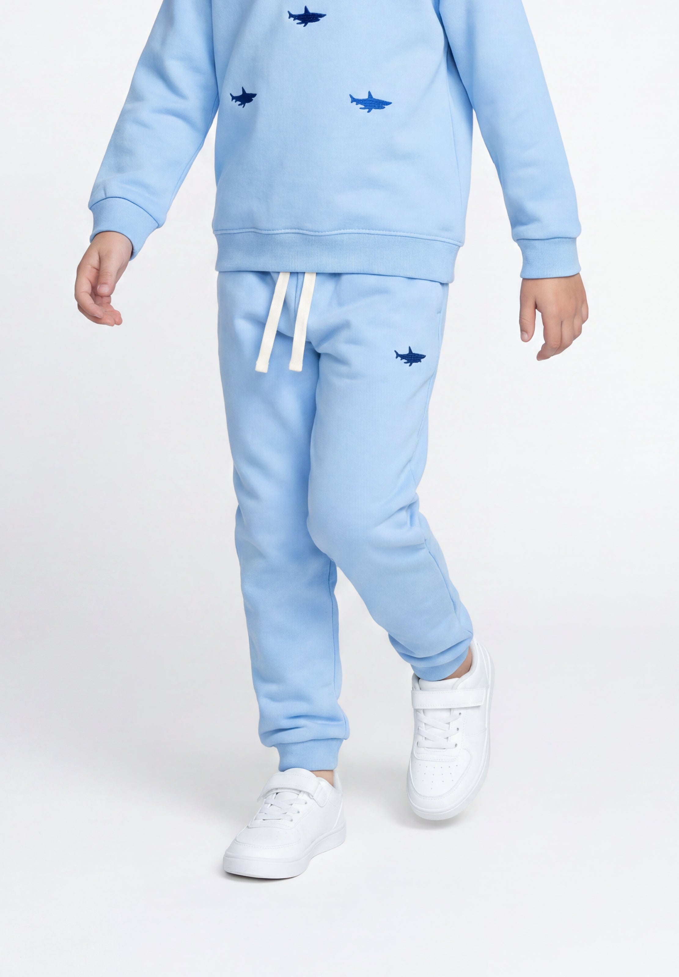Child wearing blue organic cotton sweatpants with shark design