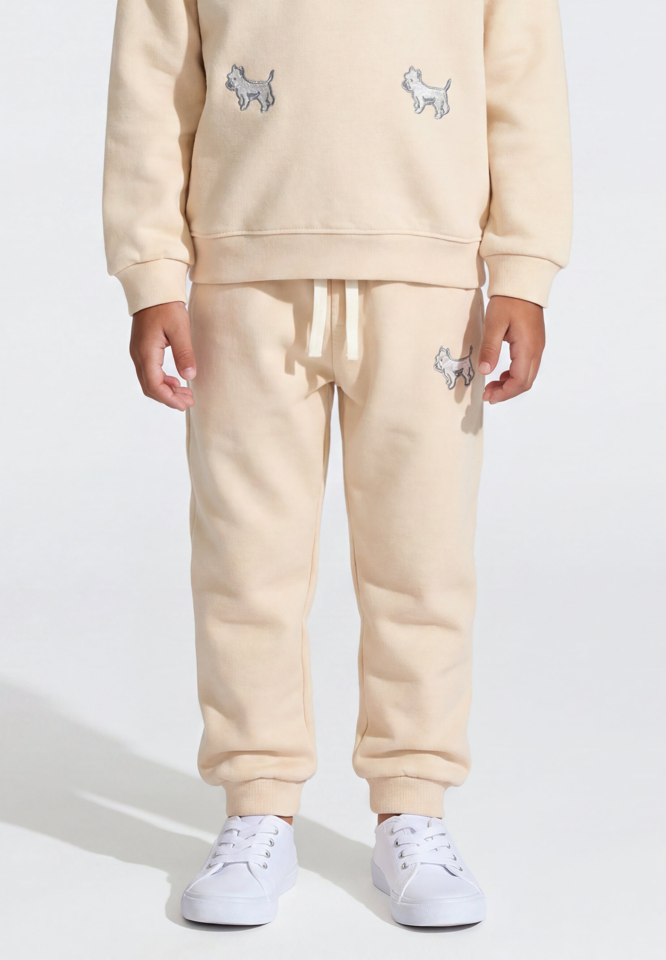 Beige kids' sweatpants featuring embroidered white puppy design