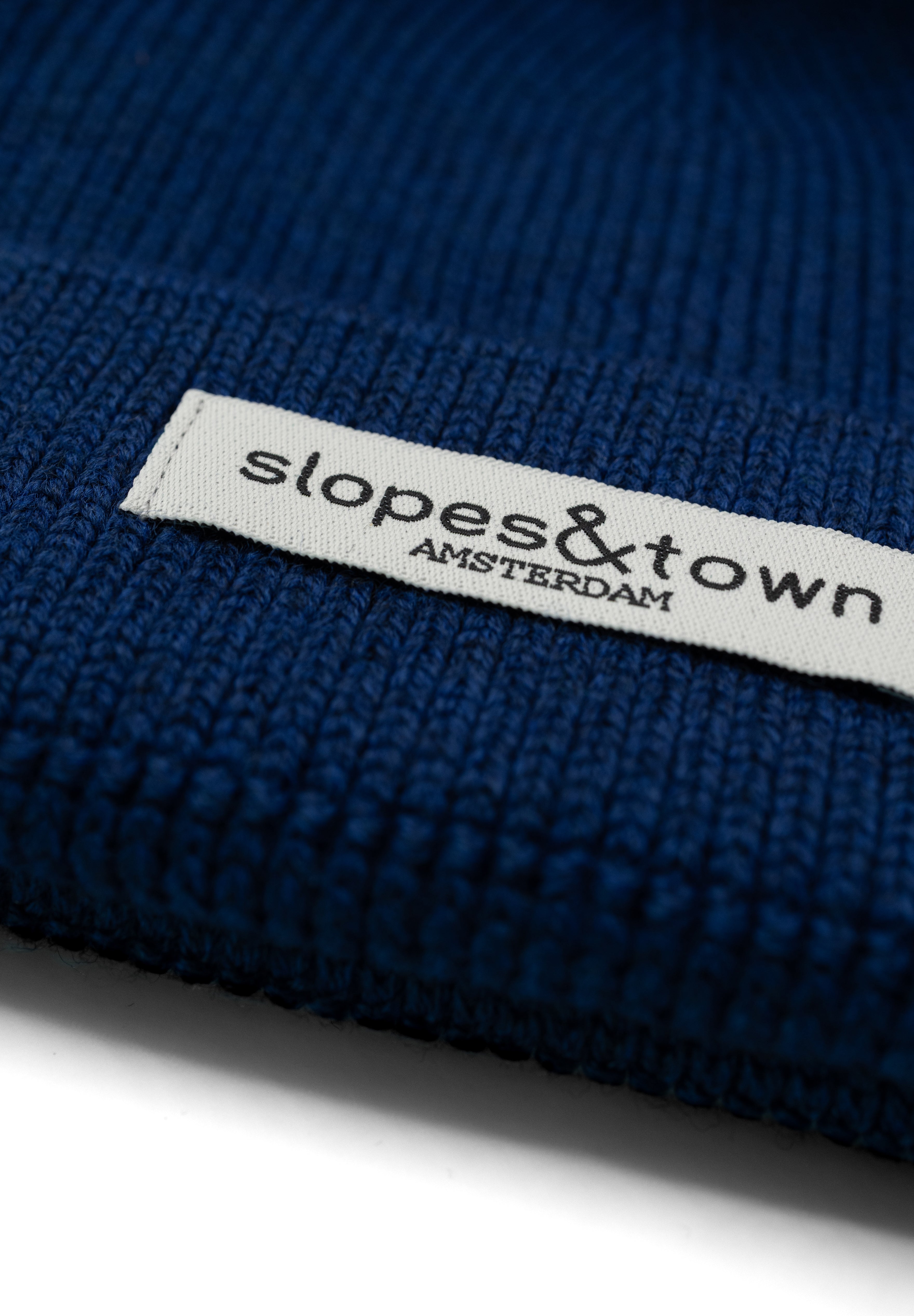 Kids merino wool beanie in navy blue, ribbed knit texture and folded cuff detail