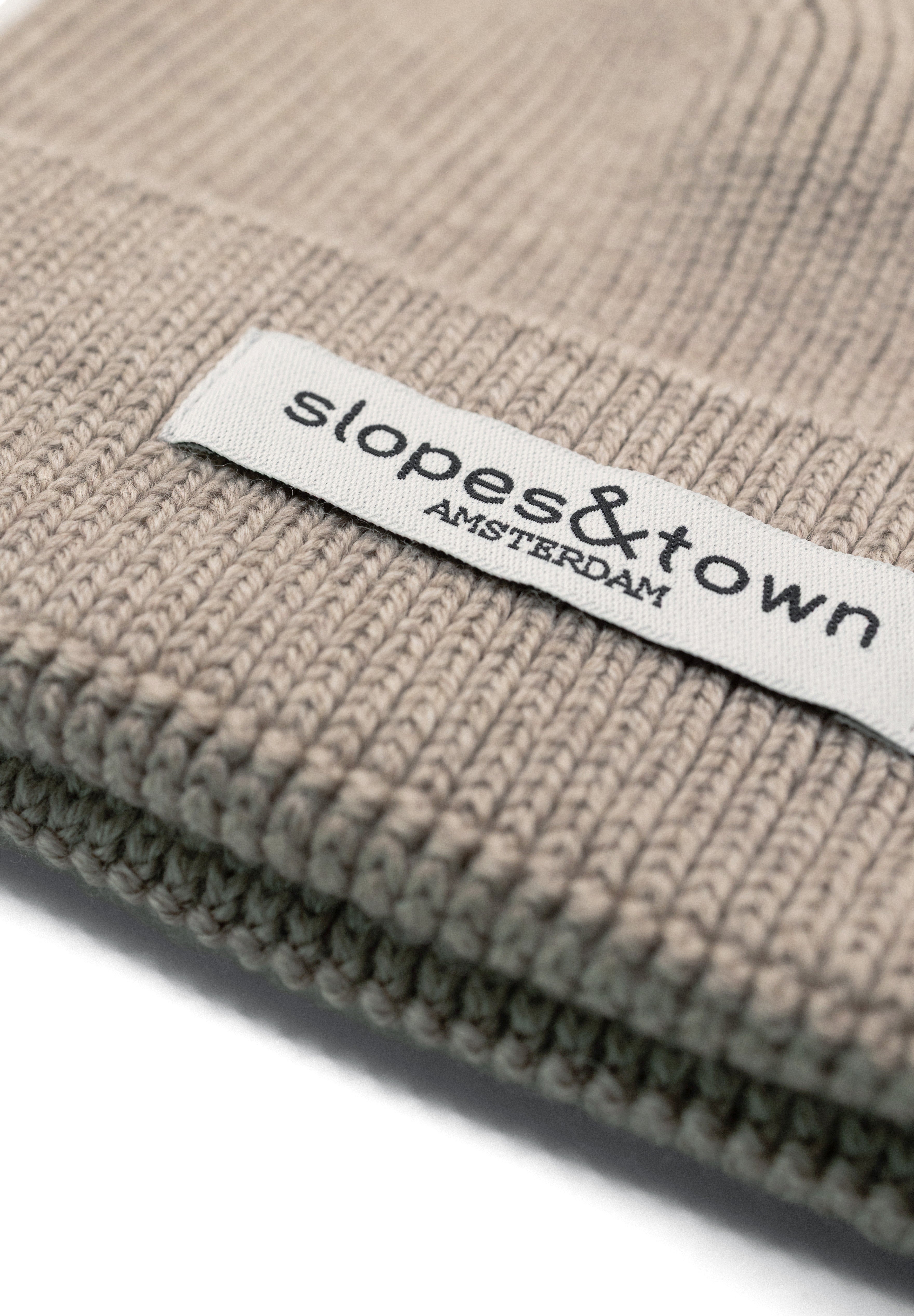 Close-up of Slopes and Town Amsterdam woven label on beige kids merino wool beanie