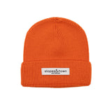 Kids merino wool beanie in orange, front view with Slopes and Town Amsterdam woven label