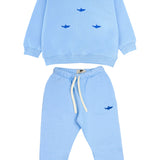 Child wearing blue sweatpants with matching shark sweatshirt
