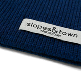 Close-up of Slopes and Town Amsterdam woven label on navy blue kids merino wool snood