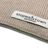 Close-up of Slopes and Town Amsterdam woven label on beige kids merino wool snood