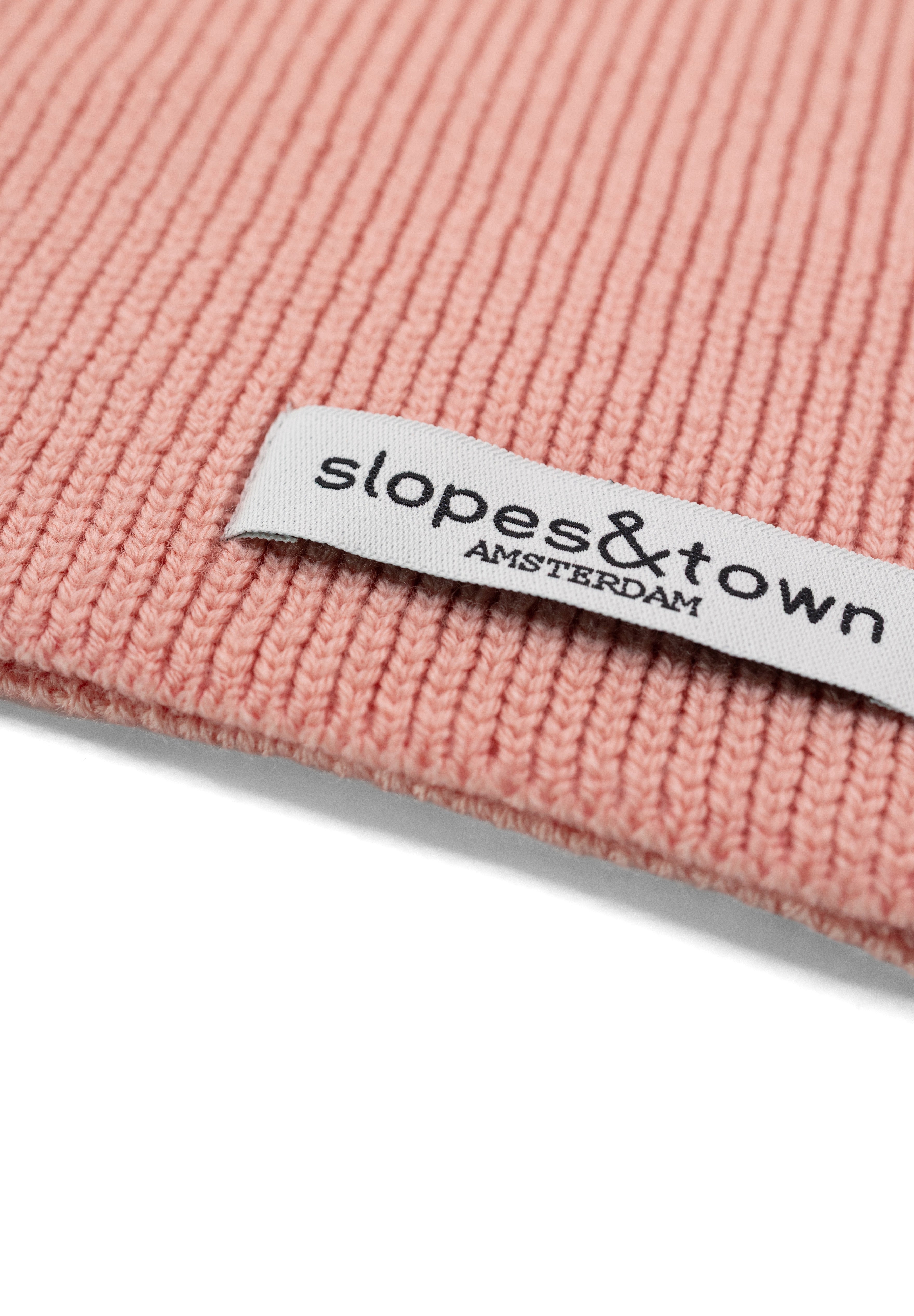 Close-up of Slopes and Town Amsterdam woven label on soft pink kids merino wool snood