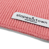 Close-up of Slopes and Town Amsterdam woven label on lemonade pink kids merino wool snood