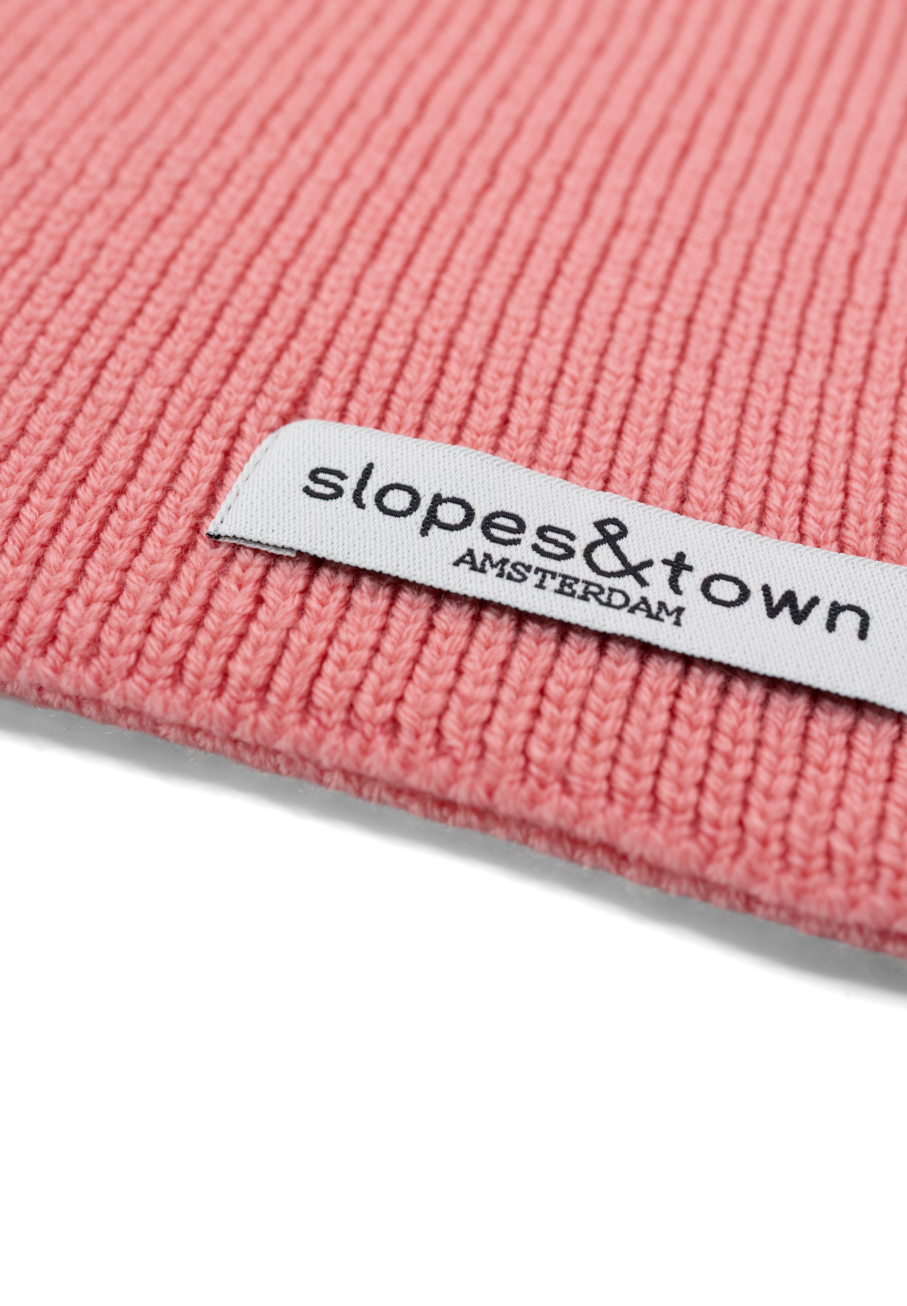 Close-up of Slopes and Town Amsterdam woven label on lemonade pink kids merino wool snood