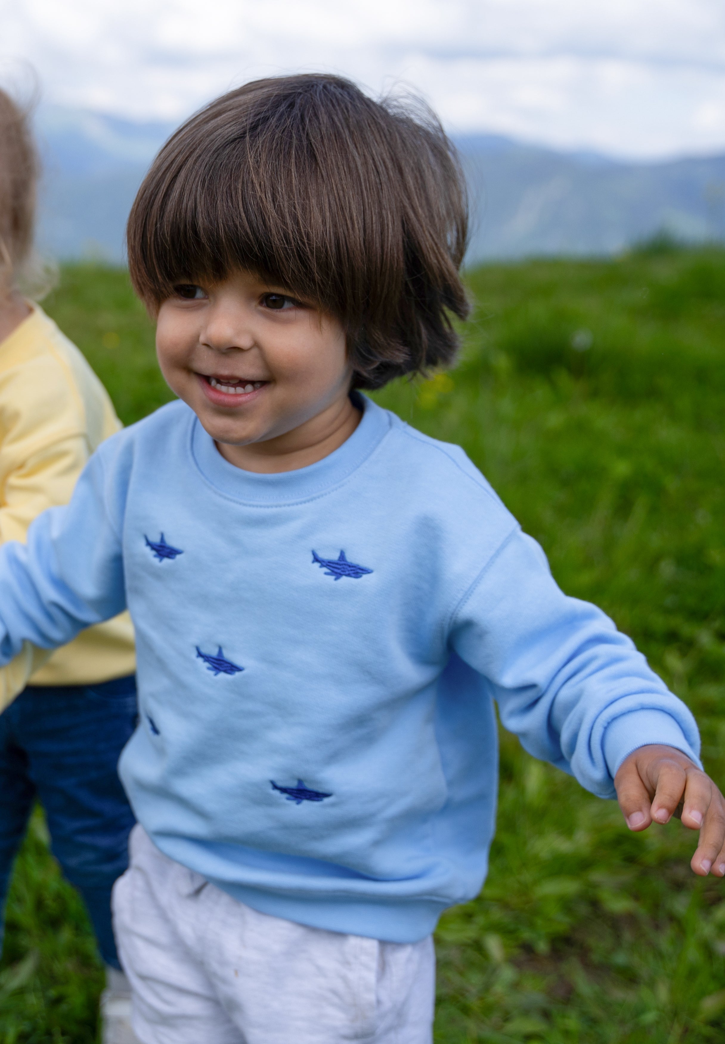 Child wearing light blue organic cotton shark sweatshirt